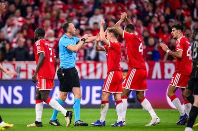 Die Bayern-Profis Joshua Kimmich und Jonathan Tah (M) bestürmen aufgebracht Schiedsrichter João Pinheiro. 