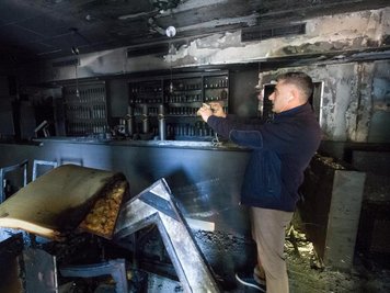 Ali Tulasoglu fotografiert die verkohlten Räume seines türkischen Restaurants in Chemnitz.