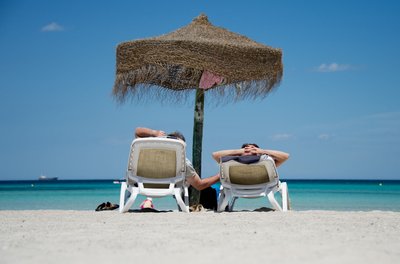 Entspannt am Strand: Wer sich vorher kurz mit möglichen Gesundheitsrisiken auseinandersetzt, ist im Urlaub relaxter. Sonnencreme nicht vergessen!