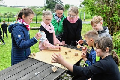 In der Kita in Naundorf gibt es auch ein "Mensch-ärgere-dich-nicht"-Spiel, hier Kinder mit Leiterin Isabel Garbacz.