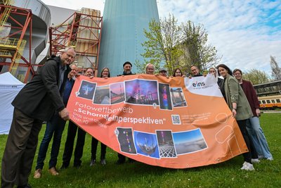 Diese Menschen schossen Fotos, die in die engere Wahl kamen. Das Plakat wird am Zaun vom Heizkraftwerk aufgehängt, dort wo viele Radfahrer vorbeikommen.