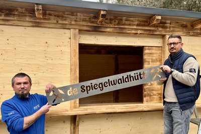 Tobias Rahm (l.) und Christian Richter vom Gebrüder Richter Werkzeugbau aus Grünhain haben das Namensschild für den neuen Imbiss gefertigt und montiert.