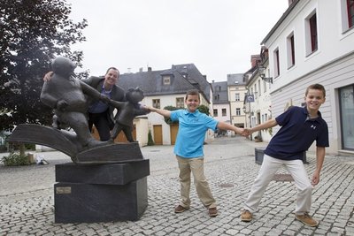 Peter Ohser, Enkel von Erich Ohser mit seinen Söhnen v.re.: Owen und Graham an der Vater-und-Sohn Skulptur vor der e.o.plauen Galerie an der Nobelstr.