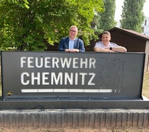 Der Amtsleiter der Feuerwehr, René Kraus (r.), und der Betriebsleiter von ITC Heckert, Bernd Stumm, am Signet vor dem Haupteingang der Feuerwache 1. 