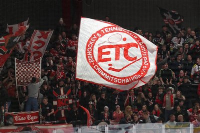 Fans der Eispiraten Crimmitschau schwenken im Stadion eine ETC-Fahne.