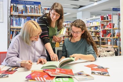 In der Stadtbibliothek haben die Auszubildende Luisa Kahnt, Bibliotheksmitarbeiterin Nancy Mickel und Praktikantin Amy Nathan (von links) einenArbeitstisch für die "Lange Nacht des Lernens" vorbereitet. 