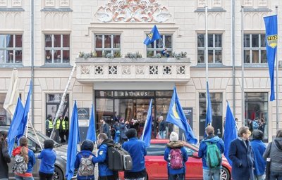 März 2020: FDJ-Demonstranten klettern auf den Rathausbalkon und schwenken die blaue Fahne. 