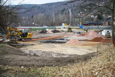 Bagger graben auf der Baustelle nahe des Auer Fußballstadions. Auf der Freifläche, die FCE-Fans bislang als Parkplatz nutzten, lässt die Volksbank Chemnitz jetzt eine neue Bankfiliale errichten.