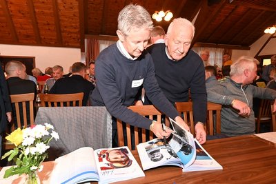 Jens Weißflog (l.) gibt Autogramme.