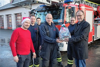 An Feuerwache Freiberg übergaben Holger Reuter (r.) und Philipp Preißler (l.) ein Präsent an Sandro Lange. 