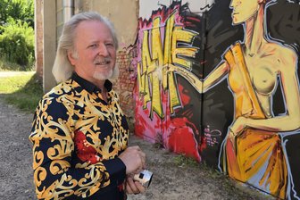 64-Jähriger hat die Welt gesehen – und wohnt nun wieder in Crimmitschau - Henry Hund hat seine kleine Kamera immer dabei. Hier schaut er sich die Graffiti-Arbeiten an den Fassaden der ehemaligen Textilfabrik an der Fichtestraße in Crimmitschau an.