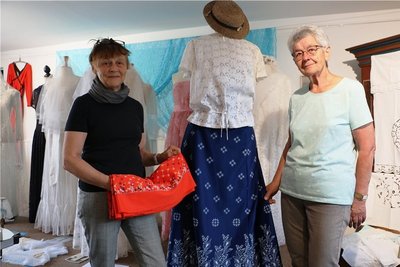 Ute Arnold (links) und Rosemarie Zimmermann, einst Meisterin im VEB Spitze - Bekleidung Pausa, haben die neue Ausstellung im Heimateck vorbereitet. Viele schöne Details sind in der Schau zu sehen. 