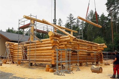 Waldarbeiter Christian Puffke bedient den Kran, der die benötigten Stämme auf das Blockhaus hebt. 