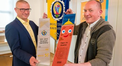 Marienbergs Oberbürgermeister André Heinrich und Maßschneidermeister Markus Seiler präsentieren die Fahnenschleife, die den Knappschaften im Zuge der Großen Bergparade überreicht wird. 