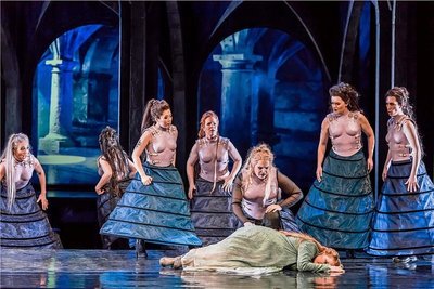 Sieglinde (Christiane Kohl, liegend) hat sich vor Wotan mit Brünnhilde (Dara Hobbs, 3. v. r.) zu den Walküren Schwertleite (Alexandra Sherman),  Ortlinde (Jana Büchner), Helmwige (Guibee Yang), Waltraute (Anne Schuldt), Gerhilde (Regine Sturm) und Grimgerde (Nathalie Senf, v. l.) geflüchtet. 