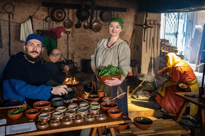 Blick in die Schlossküche, wo auf offenem Feuer und nach historischen Rezepten gekocht wird. Vorn rechts Natascha Dobos, links Sebastian Langer am Mörser.