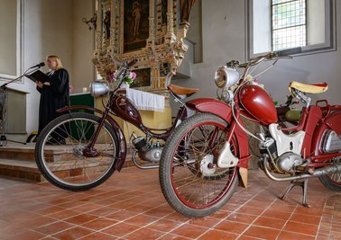 Pfarrerin Susanne Noack spricht in der Kirche - neben ihr die Kult-Mopeds.