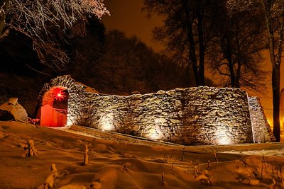 Die Ruine wird abends beleuchtet. Beim Wiederaufbau läuft nun die letzte Etappe. In der Advents- und Weihnachtszeit hing schon in Vorjahren ein Weihnachtsstern in einem wieder rekonstruierten Torbogen.