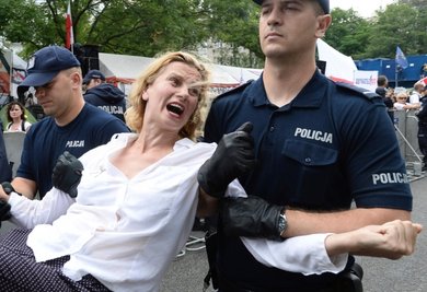 Polizisten tragen vor dem Parlamentsgebäude in Warschau eine Demonstrantin fort. Polens Regierung treibt ihre umstrittene Justizreform trotz Sanktionsdrohungen der EU-Kommission voran.