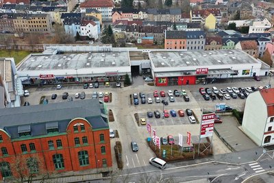 Das Fachmarktzentrum "Schwalbe" in Werdau aus der Vogelperspektive: Mehrere Handelsketten, wie Rewe und Rossmann, gehören zu den Mietern. Beim Parken wird das Autokennzeichen erfasst.