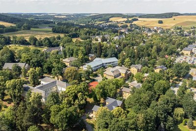 27 Fußballspiele könnten gleichzeitig auf dem Gelände des Sächsischen Krankenhauses stattfinden, wenn es denn Fußballrasen wäre. Das Typische: Zwischen viel grün lugen die gelben Klinkerbauten hervor. 