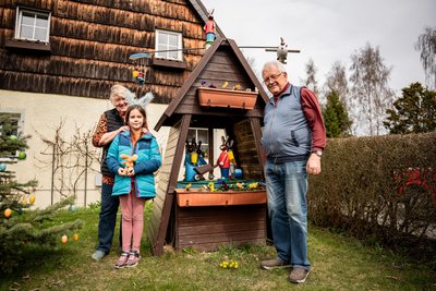 Holzdrechsler Dietmar Merkel neben seiner Osterpyramide mit seiner Frau Martina und Enkelin Mia in seinem Vorgarten in Brand-Erbisdorf.