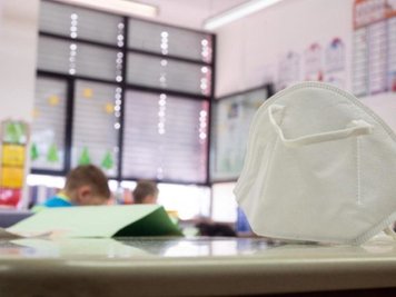 Eine FFP2-Maske liegt in einer Grundschule auf einem Tisch. 