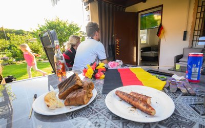 Trick 17: Wenn es rund um den Anstoß draußen noch zu hell ist, empfiehlt sich ein schattiges Plätzchen für Leinwand oder Fernseher - während man selbst in der Nähe des Grills bleiben kann.