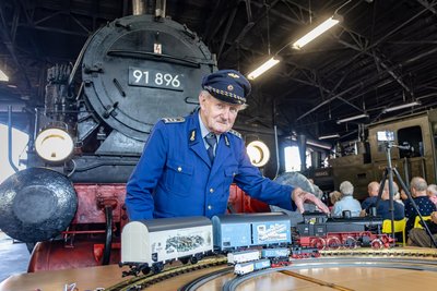 Museumsmitarbeiter Martin Müller präsentiert die neuen Modellversionen der BR 91.3 vor der historischen Dampflok im ehemaligen Bahnbetriebswerk in Chemnitz-Hilbersdorf.