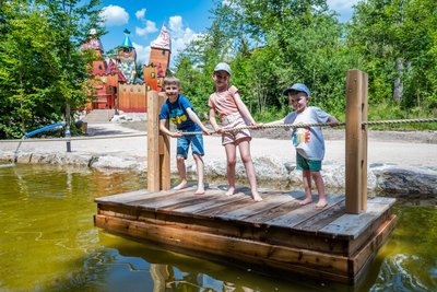 Enno, Mara und Jannes aus Chemnitz probieren sich beim Floßziehen am Wasserspielplatz in Wurzelrudis Seedorf in Eibenstock aus.