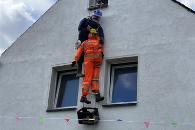 Anderswo erklimmen zwei Gestalten die Fassade eines Hauses.