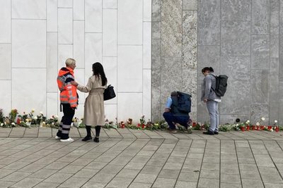 Trauernde legen Blumen und Kerzen in der Leipziger Innenstadt nieder. Eine Mitarbeiterin vom Kriseninterventionsteam leistet Beistand.