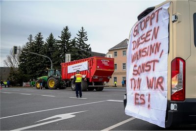 Solche Plakate mit diesem Spruch waren an fast allen Fahrzeugen befestigt. Der Traktor mit dem großen Anhänger fuhr am Ende der Kundgebung vom hinteren Teil der Kolonne bis zur Kreuzung vor. 