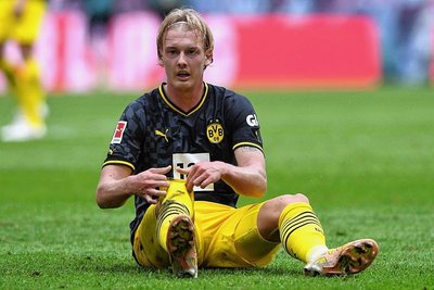 BVB-Profi Julian Brandt sitzt enttäuscht auf dem Rasen.