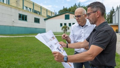Waldpark-Geschäftsführer Joachim Otto (hinten) und Sören Voigt, Präsident des Landesverbandes Kinder- und Jugenderholungszentren Sachsen, checken den Bauplan für den Anbau des Funktionsgebäudes. 