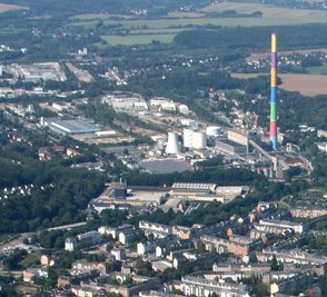 Blick auf das Heizkraftwerk von Eins Energie mit dem bunten Schornstein.