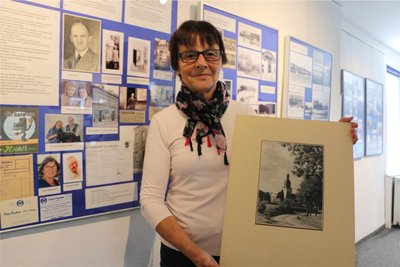 Ute Arnold zeigt eine historische Aufnahme der Kirche Ebersgrün. Sie hat die Ausstellung gestaltet.