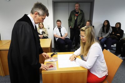 Richterin Simone Pester legt im inszenierten Zivilverfahren der „Zeugin“ Bello Beweisfotos vor. Das Verfahren war Teil des Tages der offenen Tür am Amtsgericht Freiberg.