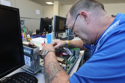 Rolf Schmidt arbeitet in Weimar an einem reparaturbedürftigen Computer.