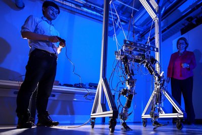Doktorand Hongxi Zhu und Professorin Ulrike Thomas probieren einen Laufroboter mit nachgiebigem Robotergelenk.