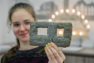 Jessica Spranger, Mitarbeiterin in der Tourist-Information, zeigt eine "Chemnitzer Platte": ein Gebäck, das an ein Betonelement eines WBS-70-Wohnblocks erinnern soll. 