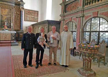 Nach etwas mehr als zwei Jahren nach seiner Geburt im Feuerwehrgerätehaus Neukirchen hat Thill jetzt auch in Neukirchen seine Taufe erhalten. Im Bild die Taufpaten Volker Ludewig, Falk Lucius mit Thill auf dem Arm, Ralf Münnich und Pfarrer Frank Pierell in der Kirche.
