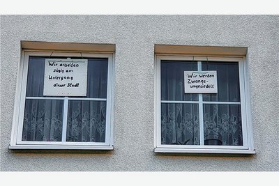 Mit handgeschriebenen Plakaten in seinen Stubenfenstern protestiert Karl-Heinz Hennig gegen den bevorstehenden Abriss des Hauses, in dem er wohnt.