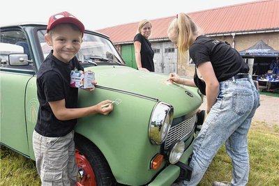 Bemalen erwünscht: Joel verziert mit Kreide die Karosse des Trabis, der in Tafelgrün daherkommt. Seine Schwester Mia hilft auch mit.