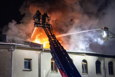 Kameraden der Feuerwehr bei Löscharbeiten in Kleinschirma von der Drehleiter aus.