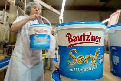 Eine Produktionsmitarbeiterin verpackt in der Bautz'ner Senf & Feinkost GmbH in Bautzen einen 10 Kilogramm Senfeimer, aufgenommen 2013.