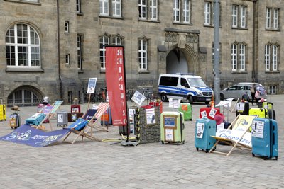 Auf dem Neumarkt demonstrieren Reisebüro mit leeren Koffern. 