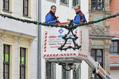Mitarbeiter der Firma Elektro-Union Freiberg - hier Thomas Freytag (l.) und Florian Breitfeld - bringen in der Freiberger Altstadt die Festbeleuchtung an.