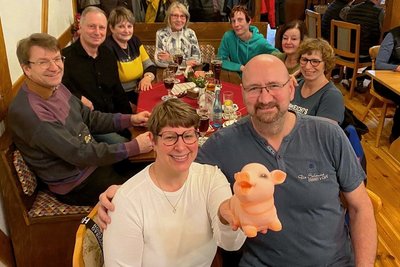 Volle Hütte in der "Scheune". Die Reichenbacher Herz-Chakra-Gruppe hatte für einen schönen Abend beim singenden Wirt Frank Wirth (vorn rechts) auch noch die passende Überraschung mitgebracht - ein über zwei Jahre gut gemästetes Sparschwein, das Gruppenchefin Ilka Burghardt in der Hand hält. 