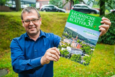 Matthias Donath, Herausgeber der Sächsischen Heimatblätter, zeigt die Ausgabe, die dem 850. Geburtstag der Stadt Aue gewidmet ist.
